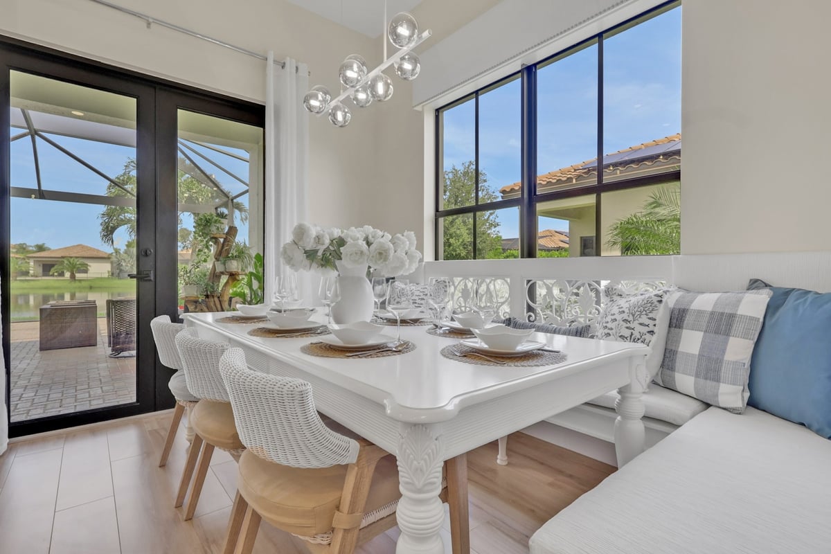 breakfast nook with white dining table banquette and garden views in naples fl full home remodel
