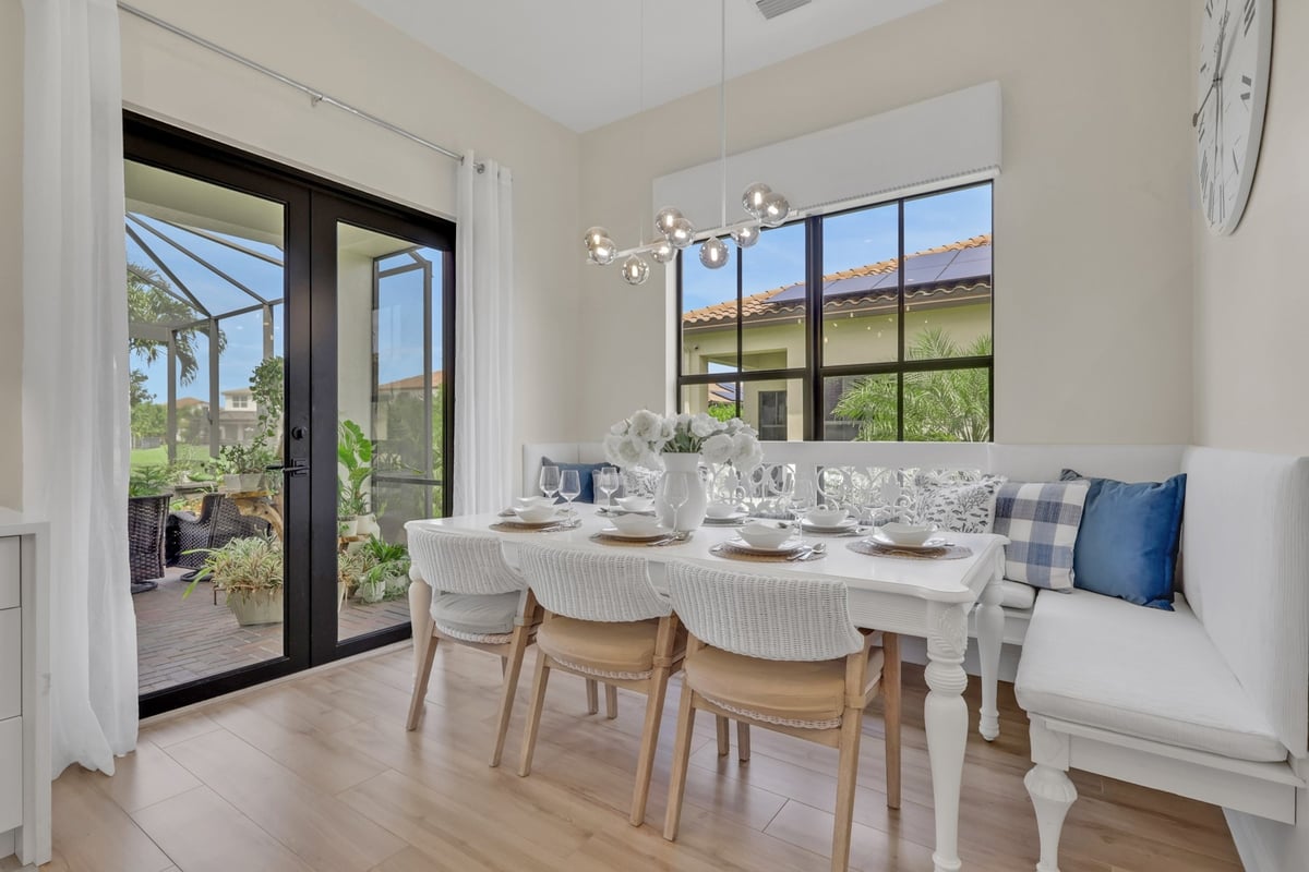 bright breakfast nook with white banquette and black framed patio doors in naples fl full home remodel