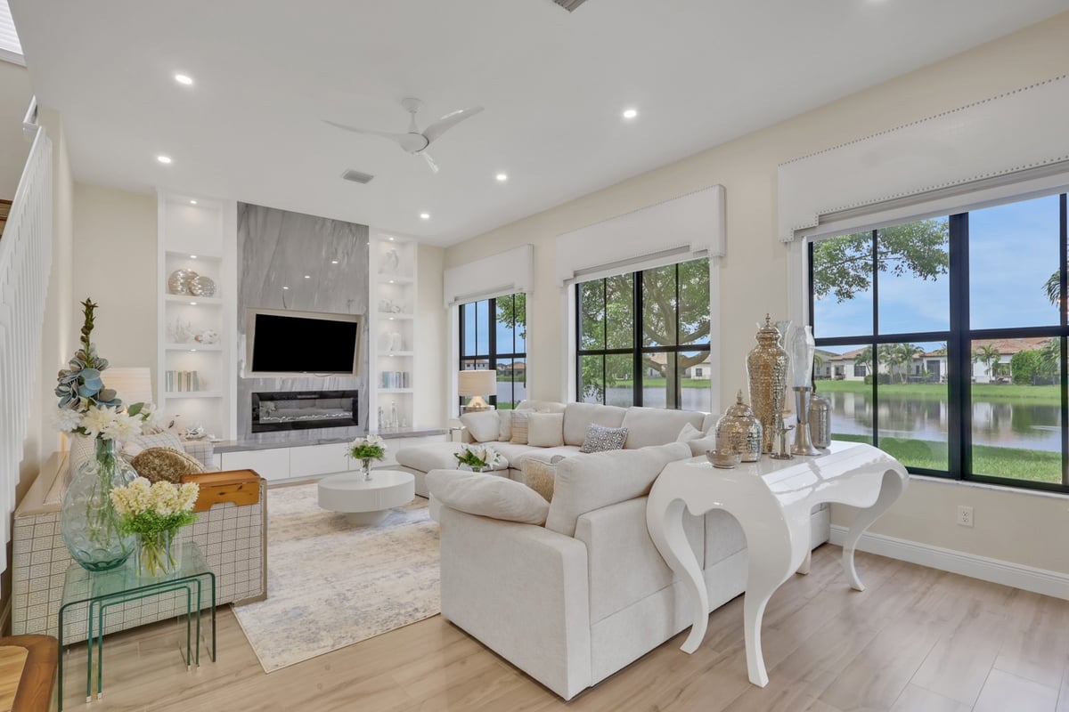 bright living room with large black framed windows and lake views in naples fl full home remodel