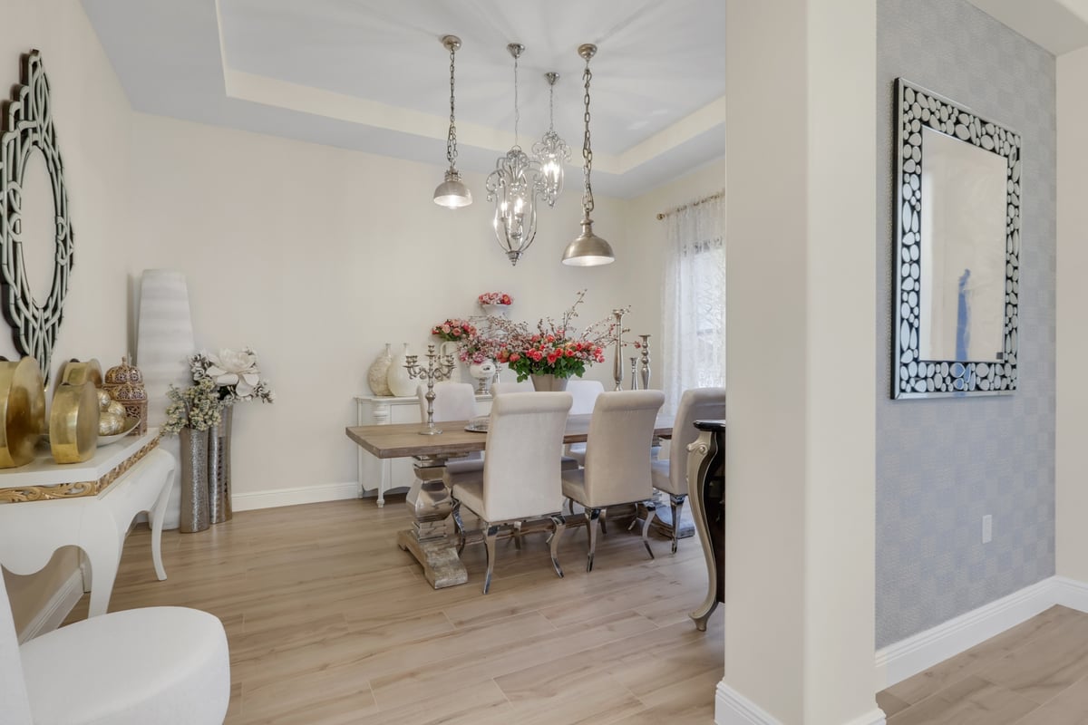 elegant dining room with wood table and statement lighting in naples fl full home remodel