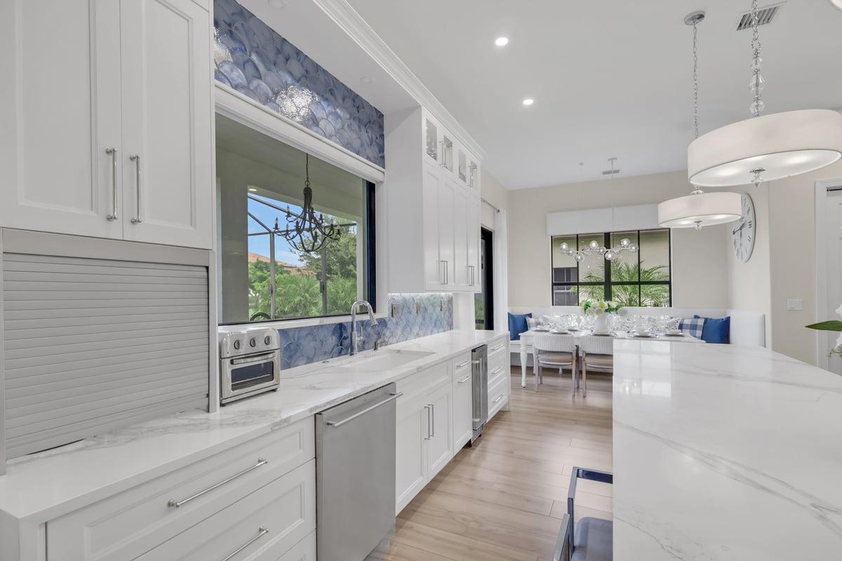 full home remodel kitchen with blue tile backsplash sink and dining nook in naples fl