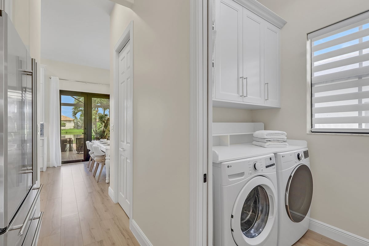 full home remodel laundry room with white cabinets washer and dryer in naples fl