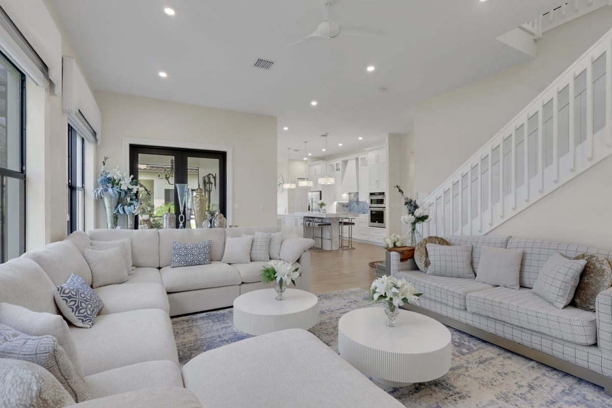 open concept living room with white seating and kitchen view in naples fl full home remodel