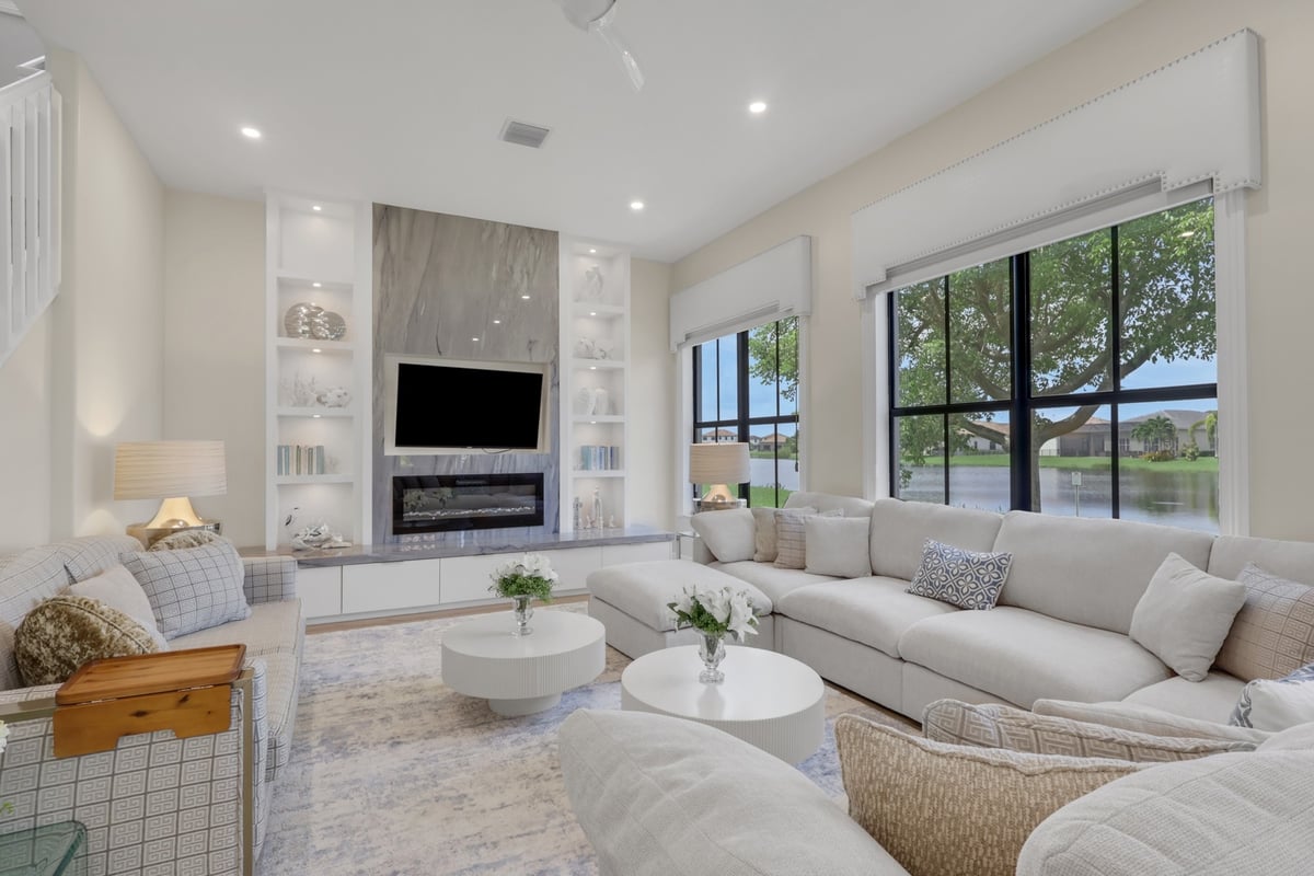 open living room with sectional sofa marble fireplace and lake views in naples fl full home remodel