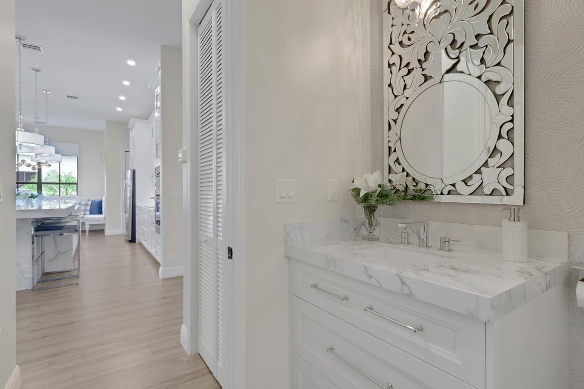 powder bathroom vanity with marble countertop and ornate mirror in naples fl full home remodel