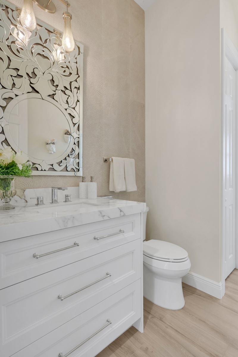 powder bathroom with white vanity marble countertop and decorative mirror in naples fl full home remodel