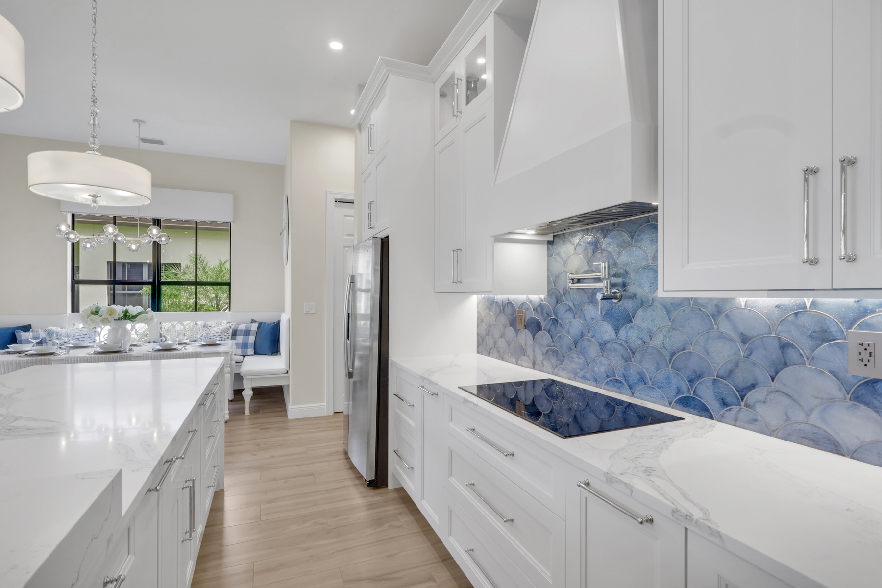 white kitchen with blue scallop tile backsplash and quartz counters in naples fl full home remodel