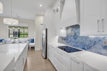 A bright, remodeled kitchen with white cabinetry. 