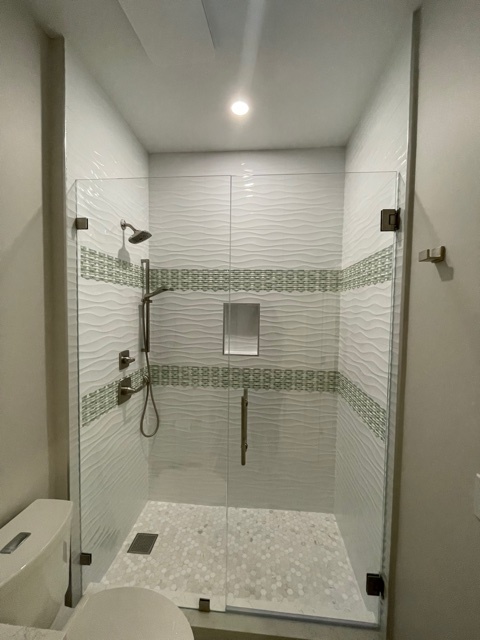 kitchen and bathroom remodel walk in shower with white wave tile and pebble floor in naples fl
