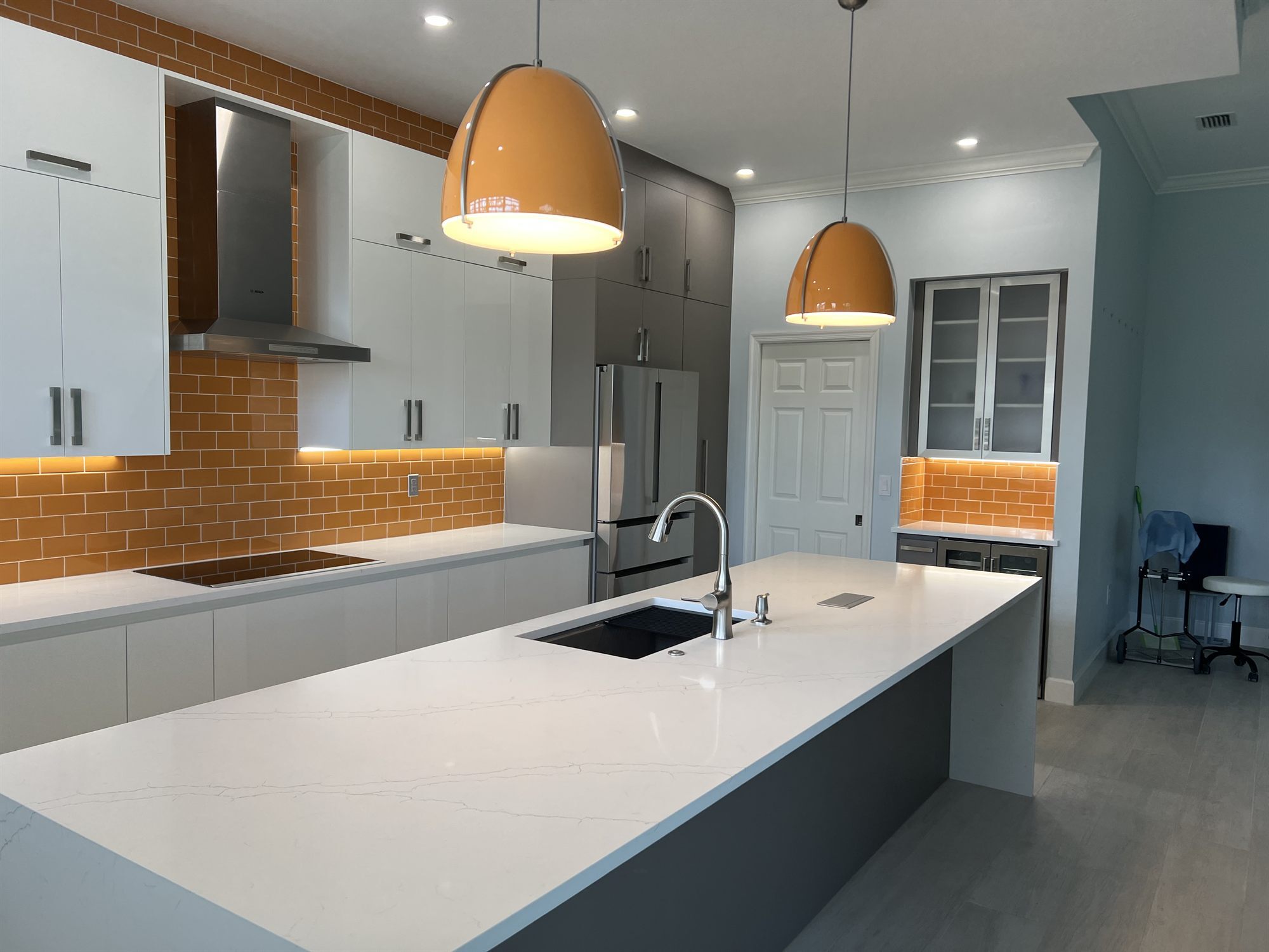 kitchen island with induction cooktop range hood and orange backsplash kitchen renovation - optimized