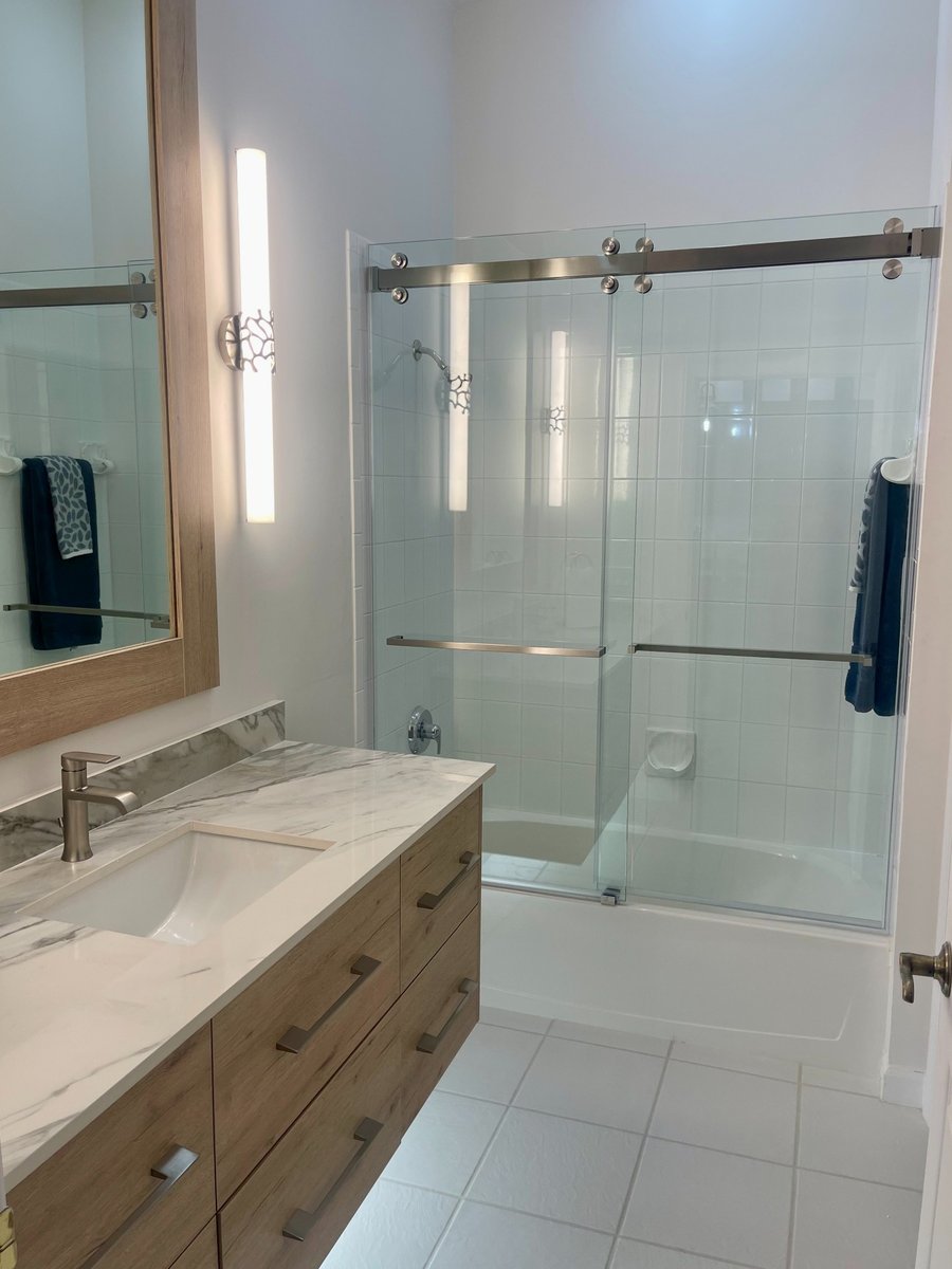 naples fl kitchen and bathroom remodel bathroom with wood vanity marble countertop and glass tub shower doors