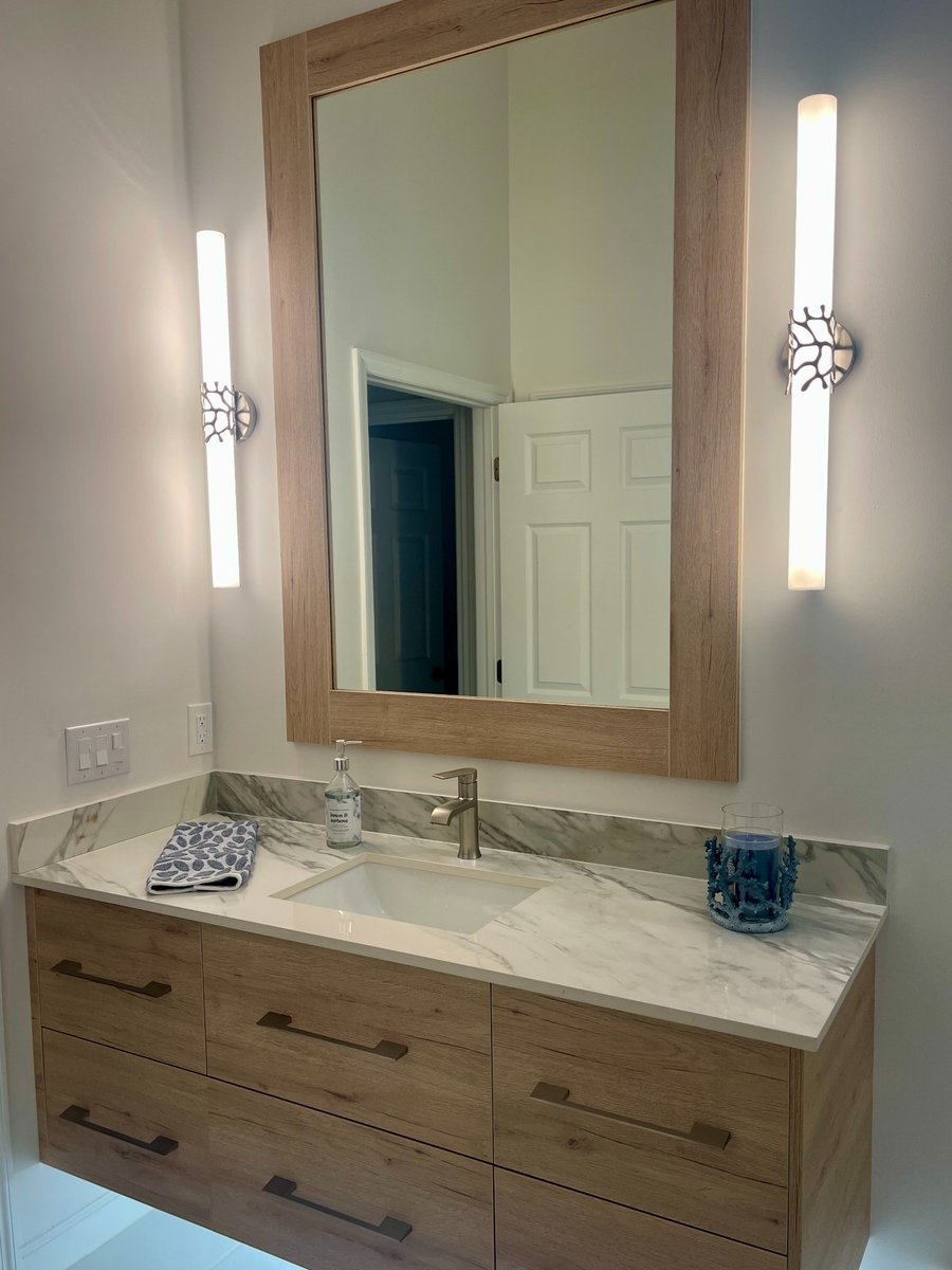 naples fl kitchen and bathroom remodel wood vanity with marble countertop framed mirror and modern wall sconces