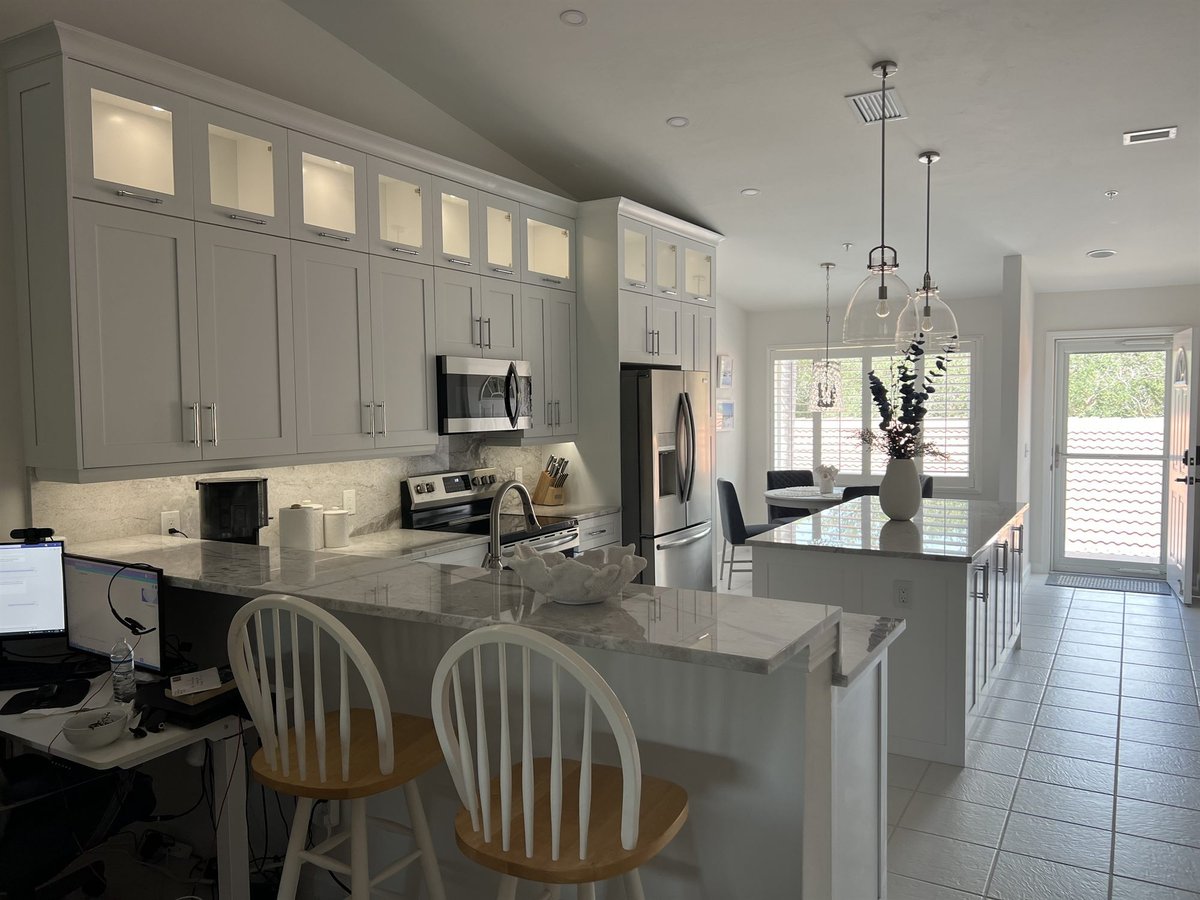 white kitchen with breakfast bar island and glass pendants kitchen remodel - optimized