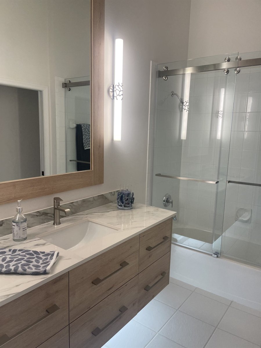 wood vanity with framed mirror and glass sliding shower bathroom remodel - optimized