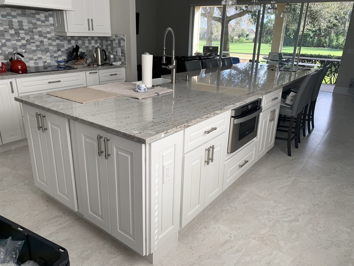 large white island with built-in wall oven and stone backsplash kitchen remodel - optimized