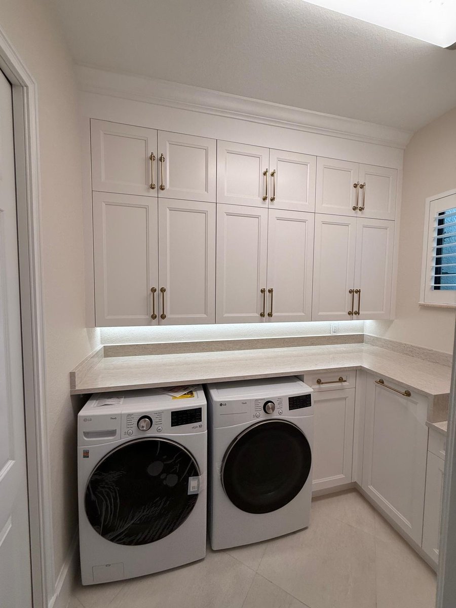 full home remodel laundry room with white cabinetry countertops and washer dryer in naples fl