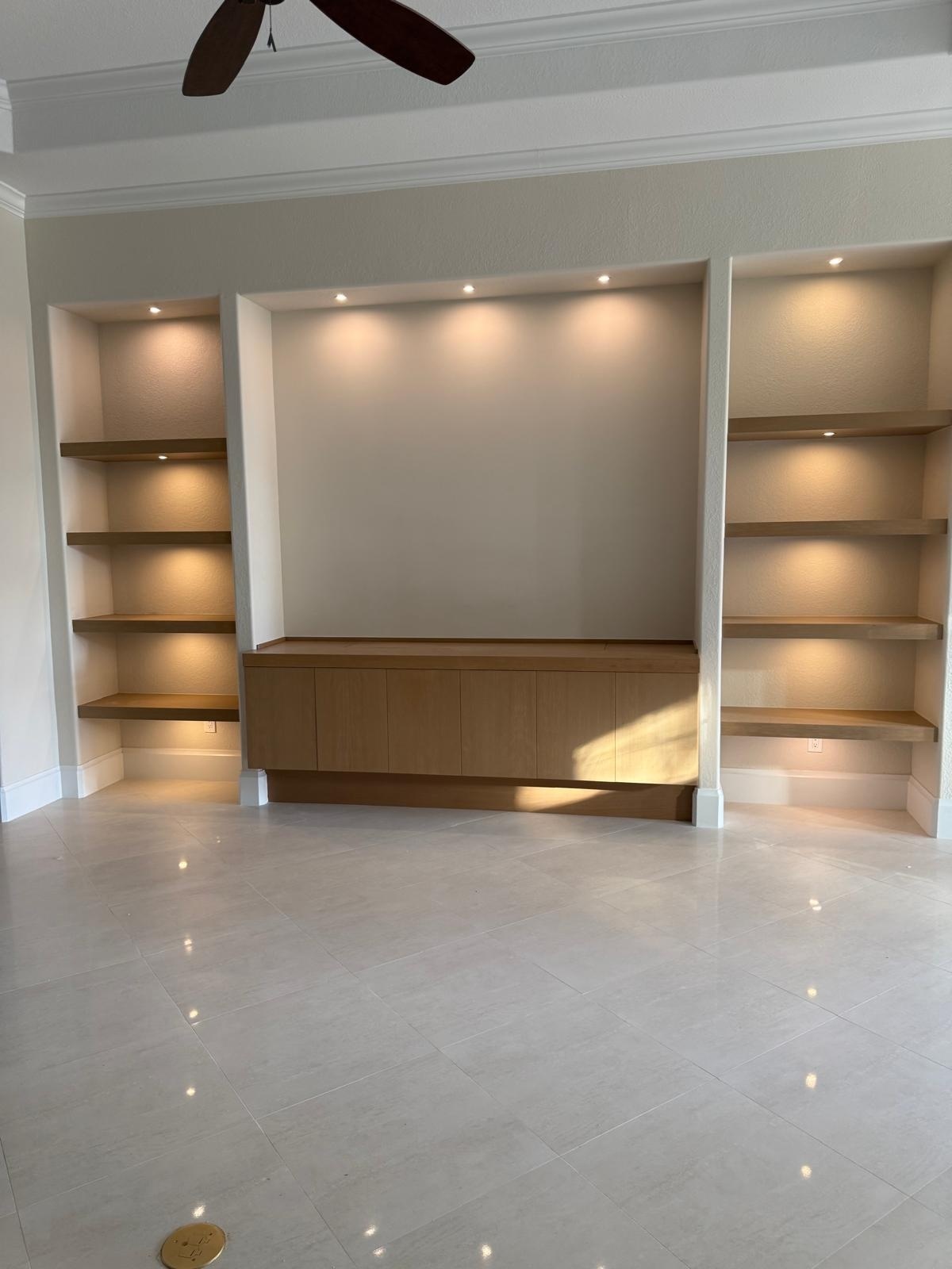 full home remodel living room built ins with illuminated wood shelves and media cabinet in naples fl