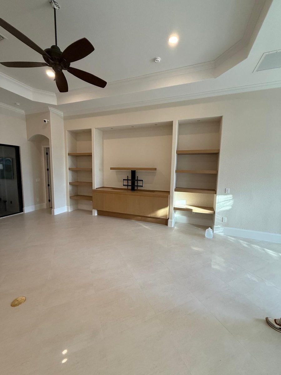 full home remodel living room with custom built in shelving and wood media cabinet in naples fl