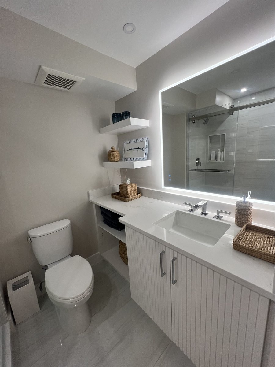 floating vanity with lighted mirror and toilet bathroom renovation