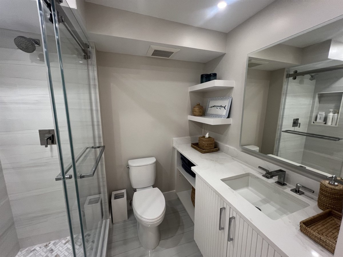 glass shower with floating vanity and open shelving bathroom renovation