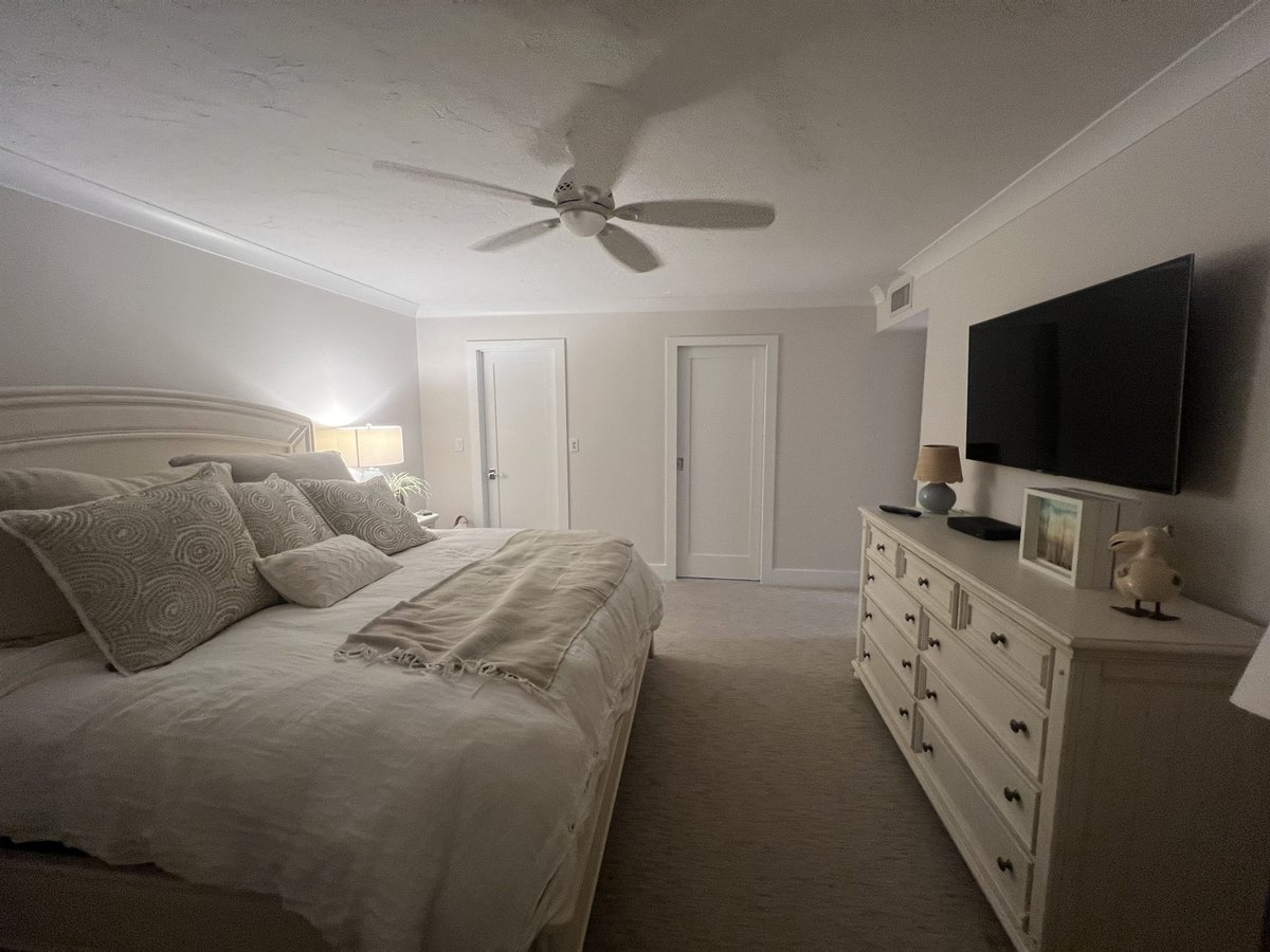 upholstered bed with dresser and ceiling fan primary bedroom renovation