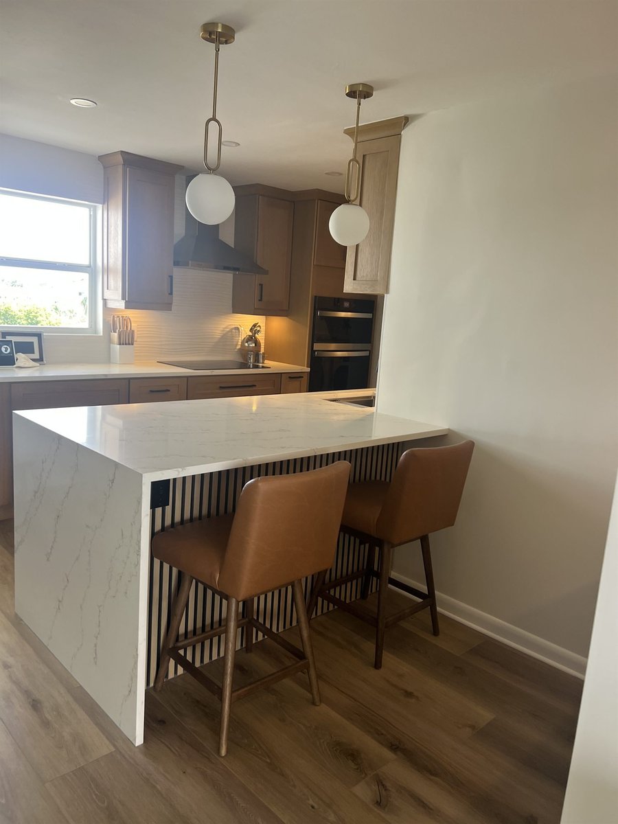 white quartz waterfall island with leather counter stools kitchen remodel