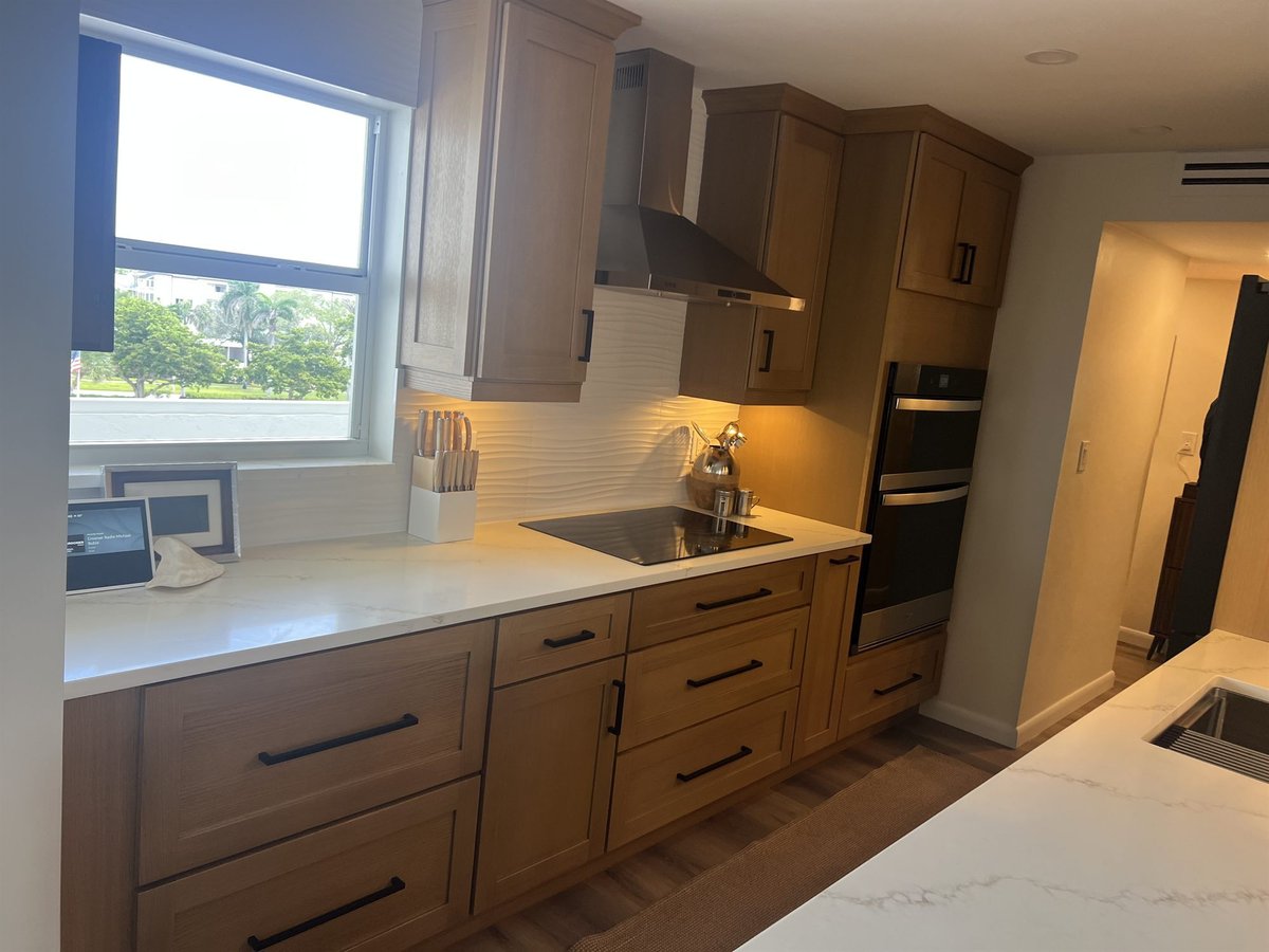 wood cabinets with induction cooktop and stainless wall oven and range hood kitchen remodel - optimized