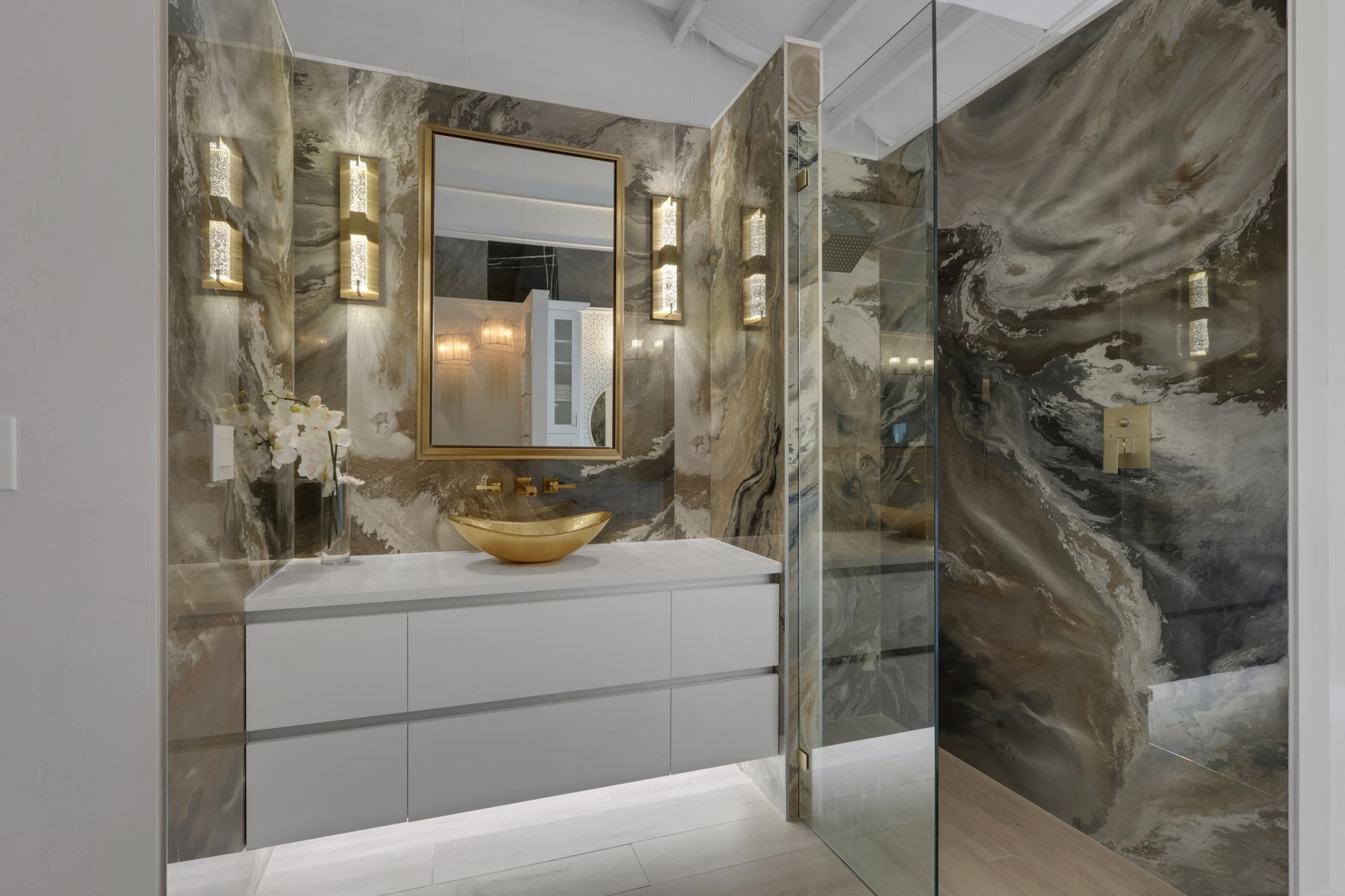 close up luxury bathroom showroom with gold vessel sink and stone backsplash in naples fl