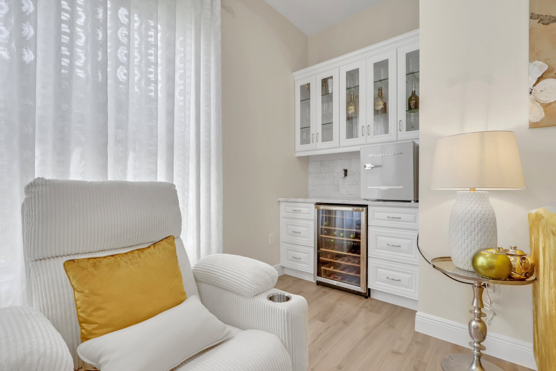 full home remodel sitting area with wine bar white recliner and gold accents in naples fl