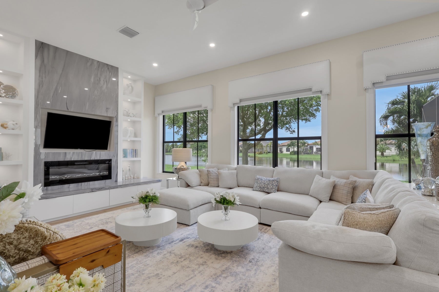 spacious living room with white sectional and custom fireplace in naples fl full home remodel