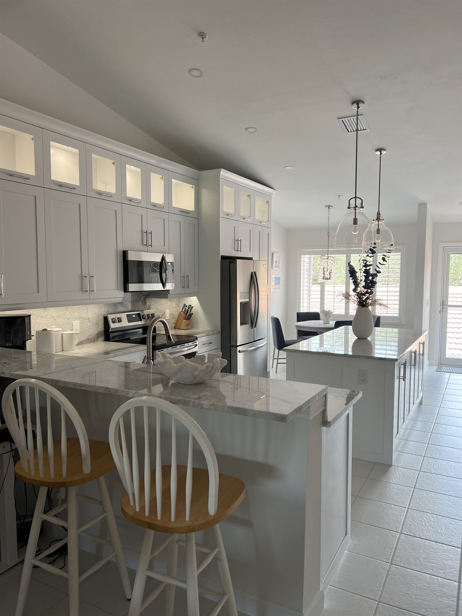 kitchen island with bar stool seating and stainless appliances kitchen remodel - optimized