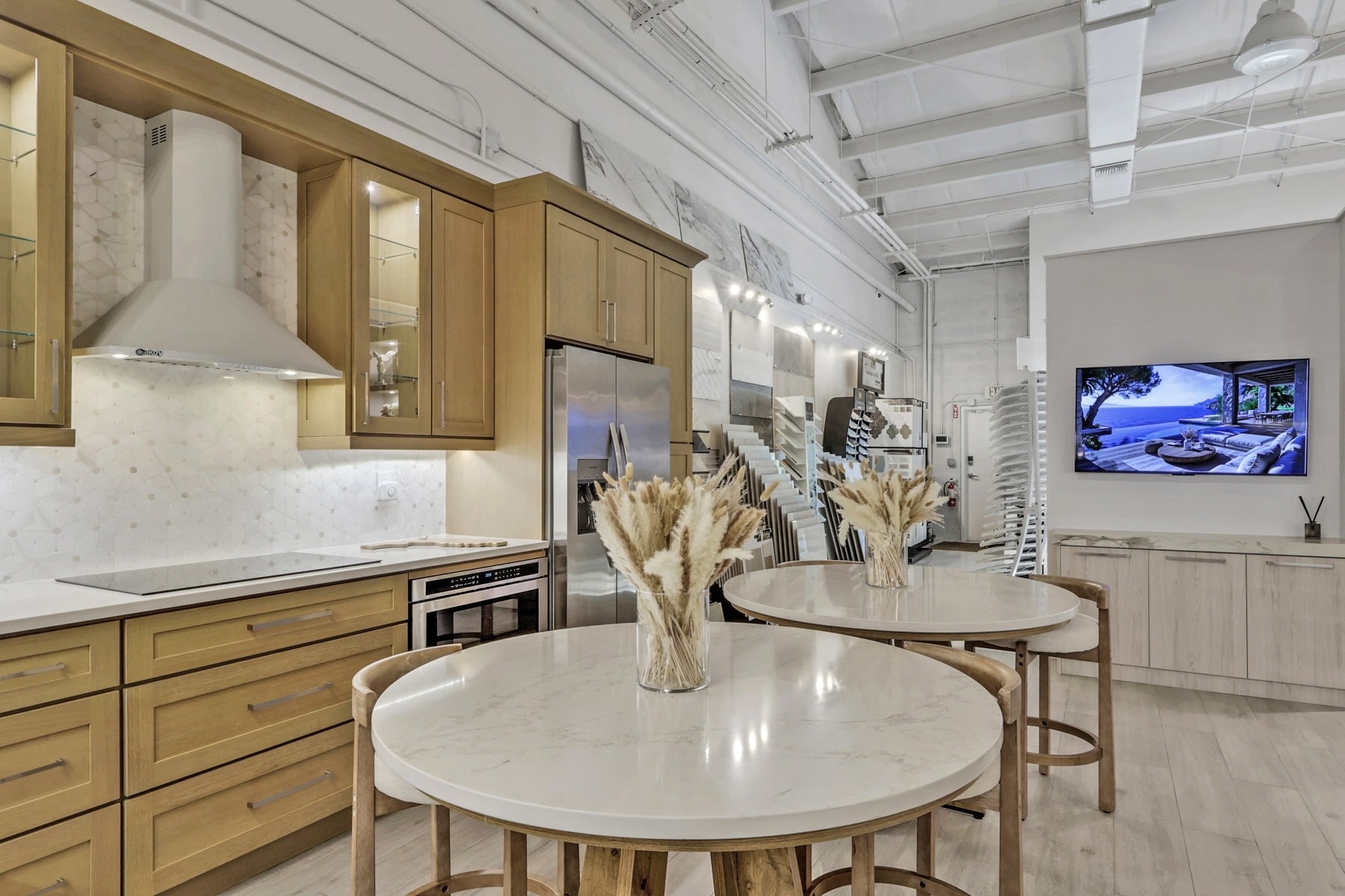 wood cabinetry kitchen showroom with white countertops and round tables in naples fl